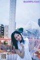 A woman in a white dress holding an umbrella.