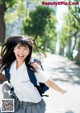 A young woman in a school uniform is running down the street.